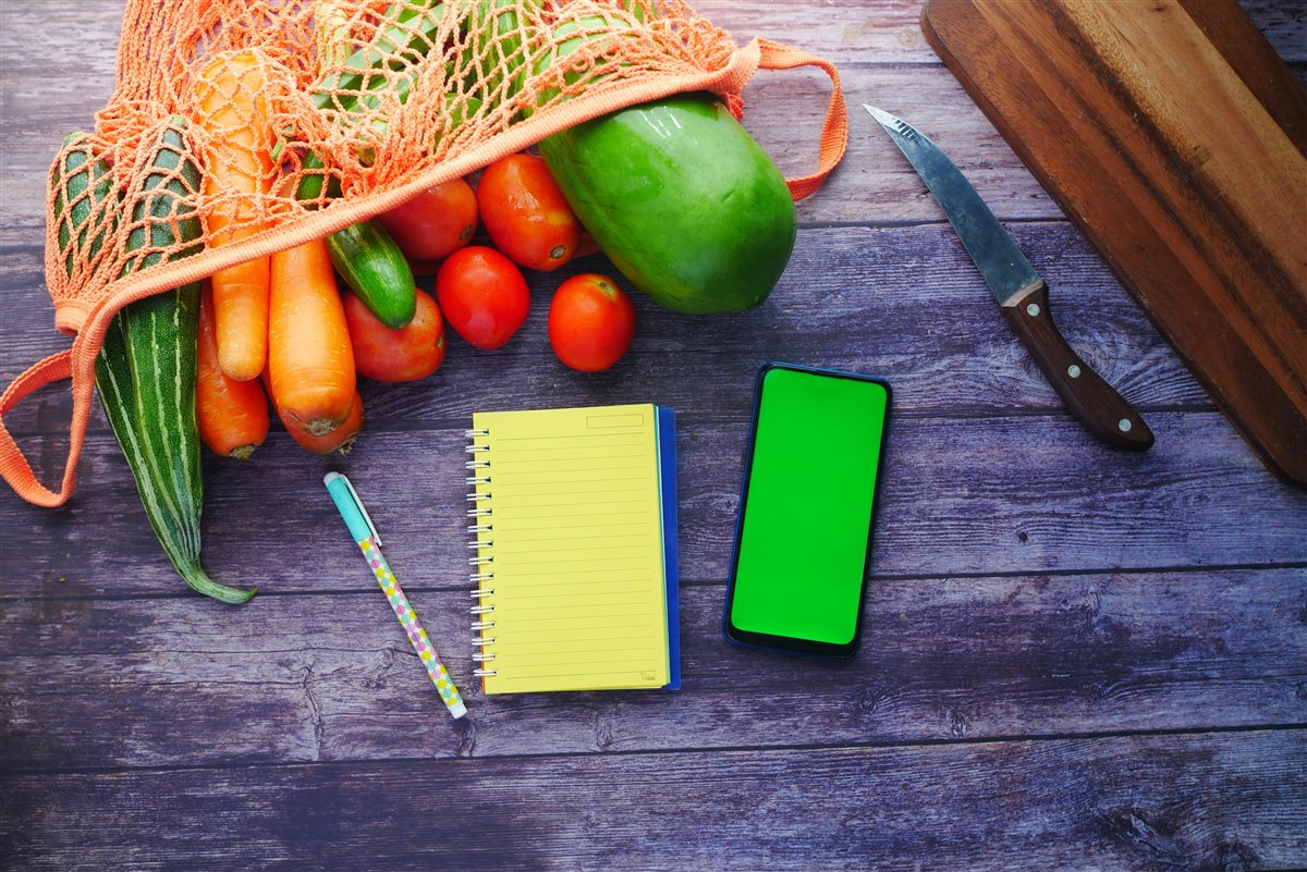 A weekly meal planner notebook with fresh ingredients